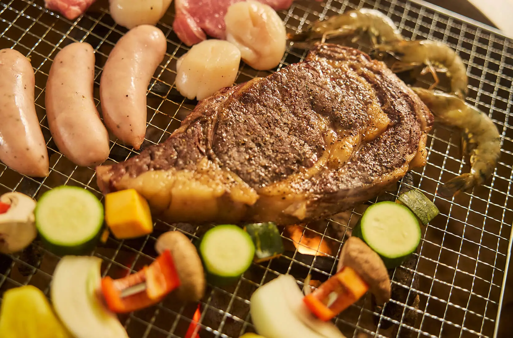 炭火で焼かれるステーキ・海鮮・野菜、OASIS大洗のグランピングBBQ夕食風景