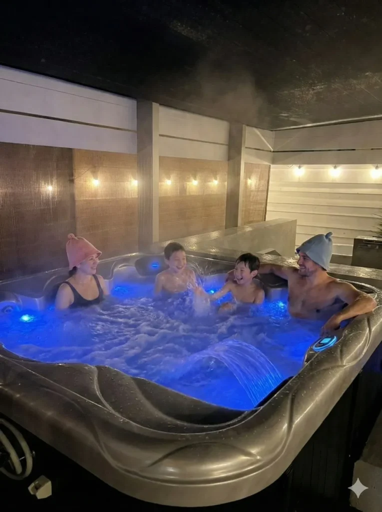 OASIS大洗の貸切SPAジャグジーでくつろぐ家族。青いLEDと湯気が幻想的な雰囲気を演出。