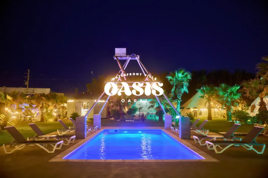 ライトアップされたプールとドームテントが並ぶOASIS-OARAIのナイトリゾート風景